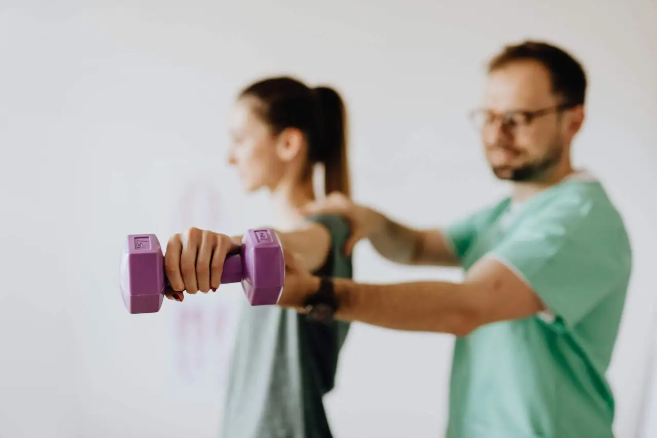 Sportphysiotherapeut betreut eine Sportlerin bei spezifischen Übungen zur Verletzungsprävention und Leistungssteigerung.